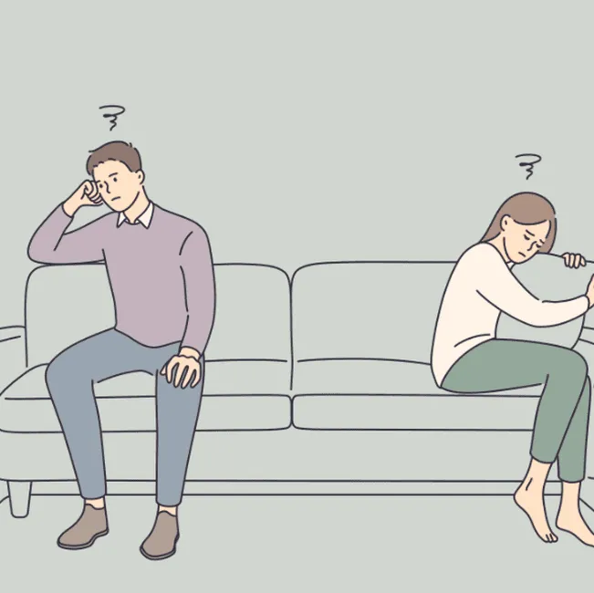 Illustration of a couple sitting apart on a sofa after an argument